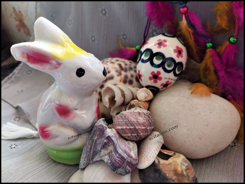 Easter bunny and a colorful Easter egg from Nuremberg Oster Markt in a Easter nest prepared at home with sea shells and feathers.