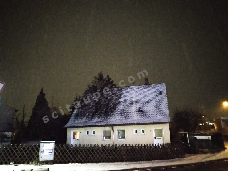 The perfect house with a picket fence looks serene after the snow fall - Winter in Germany